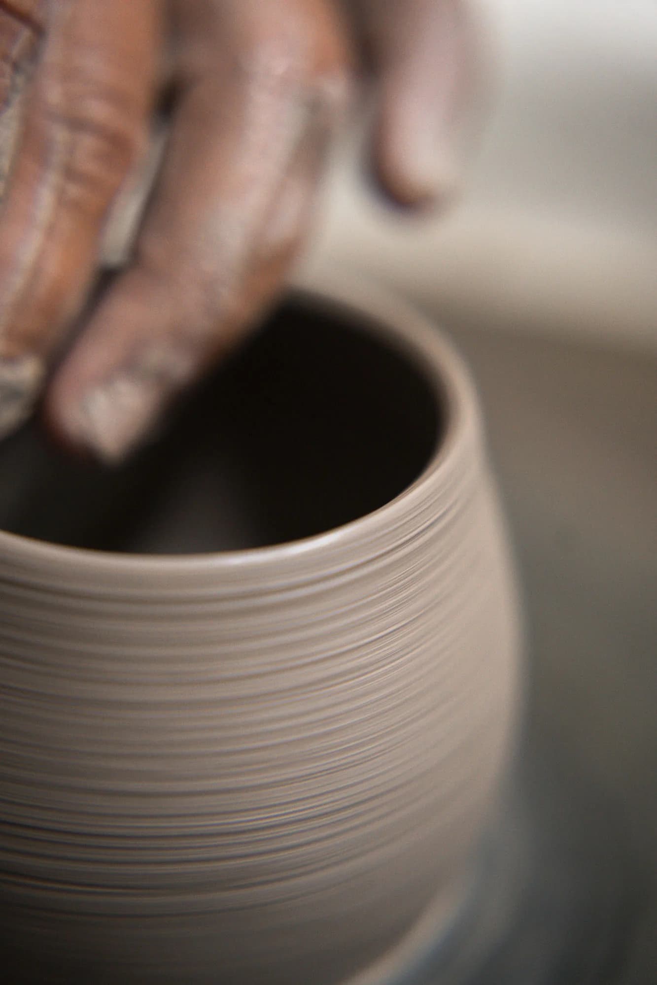 Mãos do oleiro moldando o vaso no torno